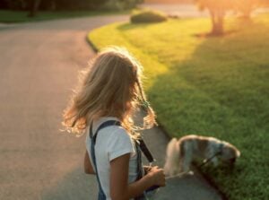 little girl walking dog artificial turf